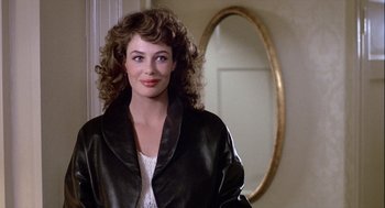 Movie still from “The Woman in Red” (1984), directed by Gene Wilder – A woman with curly hair standing in front of a mirror; Close Up shot, Over the shoulder angle