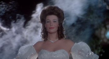 Movie still from “The Woman in Red” (1984), directed by Gene Wilder – A woman in a white dress and a necklace; Medium shot, Low angle