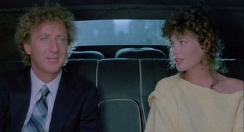 Movie still from “The Woman in Red” (1984), directed by Gene Wilder – A man and a woman sitting in the back of a car; Close Up shot, Over the shoulder angle