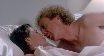 Movie still from “The Woman in Red” (1984), directed by Gene Wilder – A man and a woman in a bed with one of them kissing; Close Up shot, Over the shoulder angle