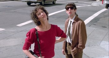 Movie still from “The Woman in Red” (1984), directed by Gene Wilder – A man and a woman standing next to each other on the street; Medium shot, Low angle