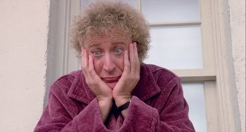 Movie still from “The Woman in Red” (1984), directed by Gene Wilder – An older woman with blonde curly hair is holding her hands to her face; Close Up shot, Low angle