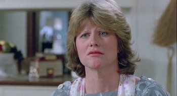 Movie still from “The Woman in Red” (1984), directed by Gene Wilder – A person wearing a dress; Close Up shot, Over the shoulder angle