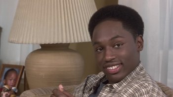Movie still from “The Wood” (1999), directed by Rick Famuyiwa – A young man sitting in front of a table lamp; Close Up shot, High angle
