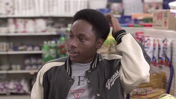 Movie still from “The Wood” (1999), directed by Rick Famuyiwa – A young black man in a black and white jacket is touching his hair; Close Up shot, Over the shoulder angle