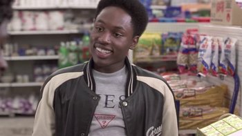 Movie still from “The Wood” (1999), directed by Rick Famuyiwa – A young man in a black and white jacket smiles for the camera; Close Up shot, Over the shoulder angle