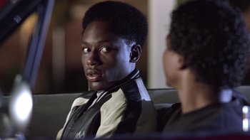 Movie still from “The Wood” (1999), directed by Rick Famuyiwa – A man sitting on top of a couch next to another man; Close Up shot, Over the shoulder angle