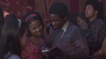 Movie still from “The Wood” (1999), directed by Rick Famuyiwa – Two young people smile while looking at a cell phone; Close Up shot, Over the shoulder angle