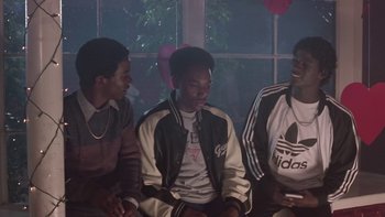 Movie still from “The Wood” (1999), directed by Rick Famuyiwa – A group of young men sitting next to each other in a room; Medium shot, Over the shoulder angle