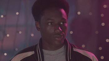 Movie still from “The Wood” (1999), directed by Rick Famuyiwa – A young man with dark skin wearing a black jacket; Close Up shot, Over the shoulder angle
