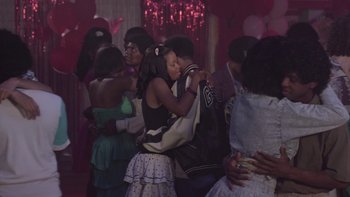 Movie still from “The Wood” (1999), directed by Rick Famuyiwa – A group of young people hugging each other in a room; Wide shot, High angle