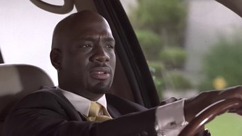 Movie still from “The Wood” (1999), directed by Rick Famuyiwa – A man in a suit and tie driving in a car; Close Up shot, Low angle