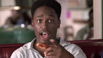 Movie still from “The Wood” (1999), directed by Rick Famuyiwa – A young man eating a piece of pizza; Close Up shot, High angle