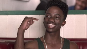 Movie still from “The Wood” (1999), directed by Rick Famuyiwa – A man with a beard and a necklace is pointing to his face; Close Up shot, Over the shoulder angle