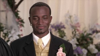 Movie still from “The Wood” (1999), directed by Rick Famuyiwa – A man in a black suit and a yellow tie; Close Up shot, Low angle