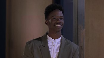 Movie still from “The Wood” (1999), directed by Rick Famuyiwa – A young man in a suit smiling for the camera; Close Up shot, High angle