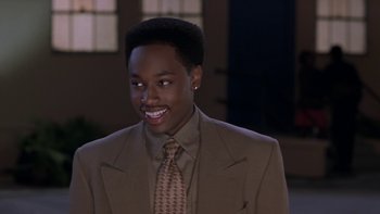 Movie still from “The Wood” (1999), directed by Rick Famuyiwa – A man in a suit and tie smiling for the camera; Close Up shot, High angle
