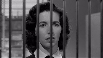 Movie still from “The Wrong Man” (1956), directed by Alfred Hitchcock – A black and white photo of a woman behind bars; Close Up shot, Low angle