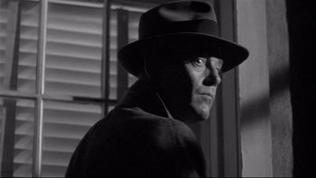 Movie still from “The Wrong Man” (1956), directed by Alfred Hitchcock – A black and white photo of a man wearing a hat; Close Up shot, Low angle