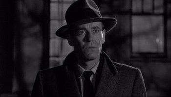 Movie still from “The Wrong Man” (1956), directed by Alfred Hitchcock – A black and white photo of a man wearing a hat; Close Up shot, Low angle