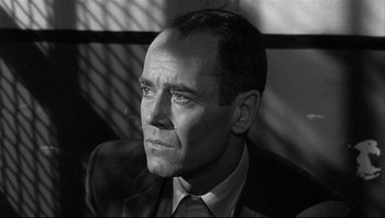 Movie still from “The Wrong Man” (1956), directed by Alfred Hitchcock – Black and white photograph of a man in a suit; Close Up shot, Over the shoulder angle