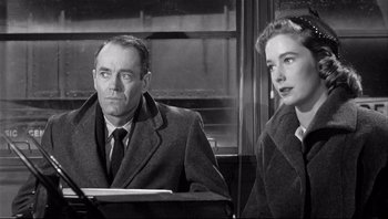 Movie still from “The Wrong Man” (1956), directed by Alfred Hitchcock – A man and a woman sitting next to each other on a train; Close Up shot, Over the shoulder angle