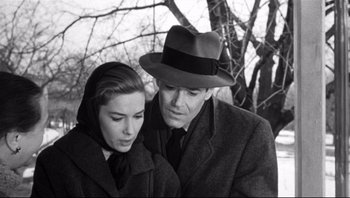 Movie still from “The Wrong Man” (1956), directed by Alfred Hitchcock – A man and a woman wearing coats and a hat; Close Up shot, Over the shoulder angle
