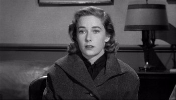 Movie still from “The Wrong Man” (1956), directed by Alfred Hitchcock – A black - and - white photo of a woman in a coat; Close Up shot, Over the shoulder angle