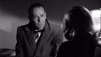 Movie still from “The Wrong Man” (1956), directed by Alfred Hitchcock – A black and white photo of a man and a woman; Close Up shot, Over the shoulder angle