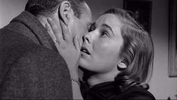 Movie still from “The Wrong Man” (1956), directed by Alfred Hitchcock – A man and a woman kissing in a black and white photo; Close Up shot, Over the shoulder angle