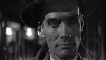 Movie still from “The Wrong Man” (1956), directed by Alfred Hitchcock – A black and white photo of a man with a hat; Close Up shot, Low angle