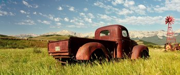 Movie still from “The Young and Prodigious T.S. Spivet” (2013), directed by Jean-Pierre Jeunet – An old red truck in the middle of a grassy field; Extreme Wide shot, Low angle