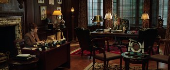 Movie still from “The Young and Prodigious T.S. Spivet” (2013), directed by Jean-Pierre Jeunet – A woman sitting at a desk in a living room; Wide shot, High angle