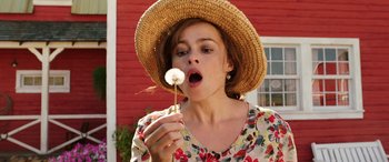 Movie still from “The Young and Prodigious T.S. Spivet” (2013), directed by Jean-Pierre Jeunet – A woman in a straw hat is holding a dandelion; Close Up shot, Low angle