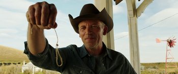 Movie still from “The Young and Prodigious T.S. Spivet” (2013), directed by Jean-Pierre Jeunet – A man wearing a cowboy hat and holding a rope; Close Up shot, Low angle