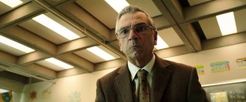 Movie still from “The Young and Prodigious T.S. Spivet” (2013), directed by Jean-Pierre Jeunet – An older man in a suit and tie looking at the camera; Close Up shot, Low angle