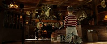 Movie still from “The Young and Prodigious T.S. Spivet” (2013), directed by Jean-Pierre Jeunet – Two boys are sitting on a couch in a room with stuffed animals; Wide shot, Low angle
