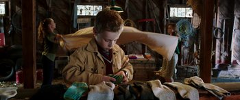Movie still from “The Young and Prodigious T.S. Spivet” (2013), directed by Jean-Pierre Jeunet – A young boy looking at his cell phone; Medium shot, Low angle