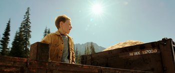 Movie still from “The Young and Prodigious T.S. Spivet” (2013), directed by Jean-Pierre Jeunet – A young boy standing on top of a wooden platform; Medium shot, Low angle