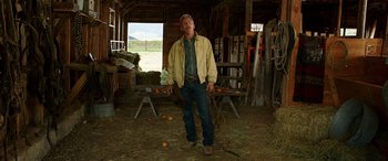 Movie still from “The Young and Prodigious T.S. Spivet” (2013), directed by Jean-Pierre Jeunet – A man standing in a barn holding a rope; Wide shot, Low angle