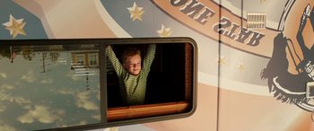 Movie still from “The Young and Prodigious T.S. Spivet” (2013), directed by Jean-Pierre Jeunet – A young boy hanging out of the window of an amusement ride; Medium shot, Low angle