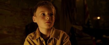 Movie still from “The Young and Prodigious T.S. Spivet” (2013), directed by Jean-Pierre Jeunet – A young boy in a brown shirt looking up; Close Up shot, Low angle