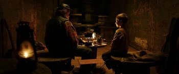 Movie still from “The Young and Prodigious T.S. Spivet” (2013), directed by Jean-Pierre Jeunet – A man and a boy sitting at a table with a glass of wine; Medium shot, Over the shoulder angle