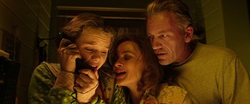 Movie still from “The Young and Prodigious T.S. Spivet” (2013), directed by Jean-Pierre Jeunet – A woman and a man and a child are looking at a cell phone; Close Up shot, Overhead angle