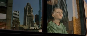 Movie still from “The Young and Prodigious T.S. Spivet” (2013), directed by Jean-Pierre Jeunet – A boy looking out of a window at a city skyline; Medium shot, High angle