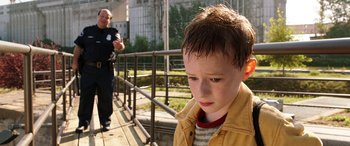 Movie still from “The Young and Prodigious T.S. Spivet” (2013), directed by Jean-Pierre Jeunet – A young boy standing next to an older man on a bridge; Close Up shot, High angle