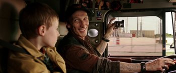 Movie still from “The Young and Prodigious T.S. Spivet” (2013), directed by Jean-Pierre Jeunet – A man holding up a camera while sitting next to a boy; Close Up shot, Over the shoulder angle