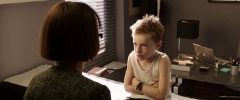 Movie still from “The Young and Prodigious T.S. Spivet” (2013), directed by Jean-Pierre Jeunet – A young boy sitting in front of an older woman; Medium shot, Over the shoulder angle