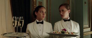 Movie still from “The Young and Prodigious T.S. Spivet” (2013), directed by Jean-Pierre Jeunet – A woman in a white tuxedo holding a tray of food; Close Up shot, Over the shoulder angle