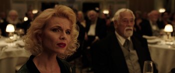 Movie still from “The Young and Prodigious T.S. Spivet” (2013), directed by Jean-Pierre Jeunet – A woman with blonde hair standing next to a man in a black suit; Close Up shot, Over the shoulder angle